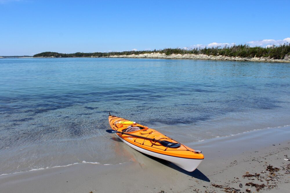 橙色皮艇在海滩与海蓝色的海洋，新斯科舍省，加拿大