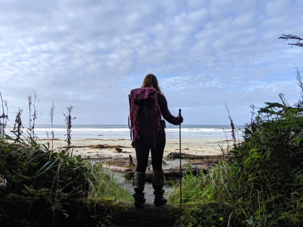 杰玛背对着镜头站在一条通往海滩的徒步小径的尽头，前方可以看到太平洋