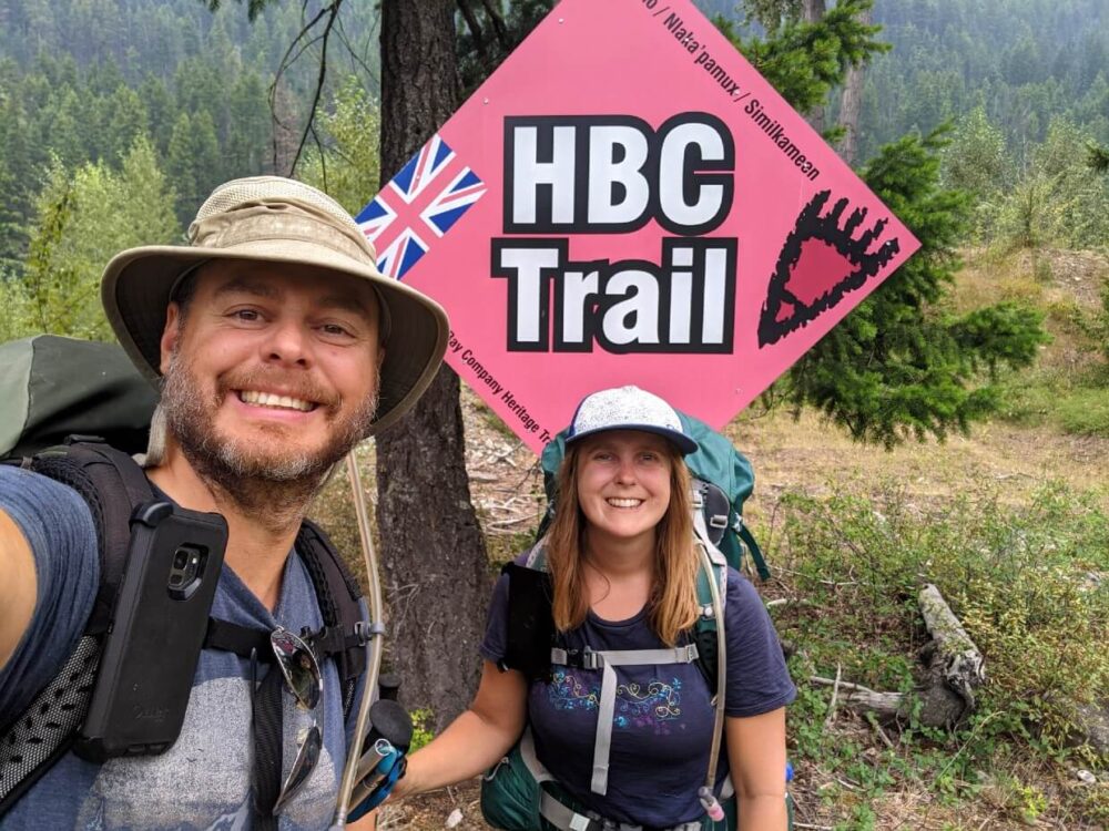 JR和杰玛完成HBC步道的自拍照，与大红钻形HBC步道标志在背景