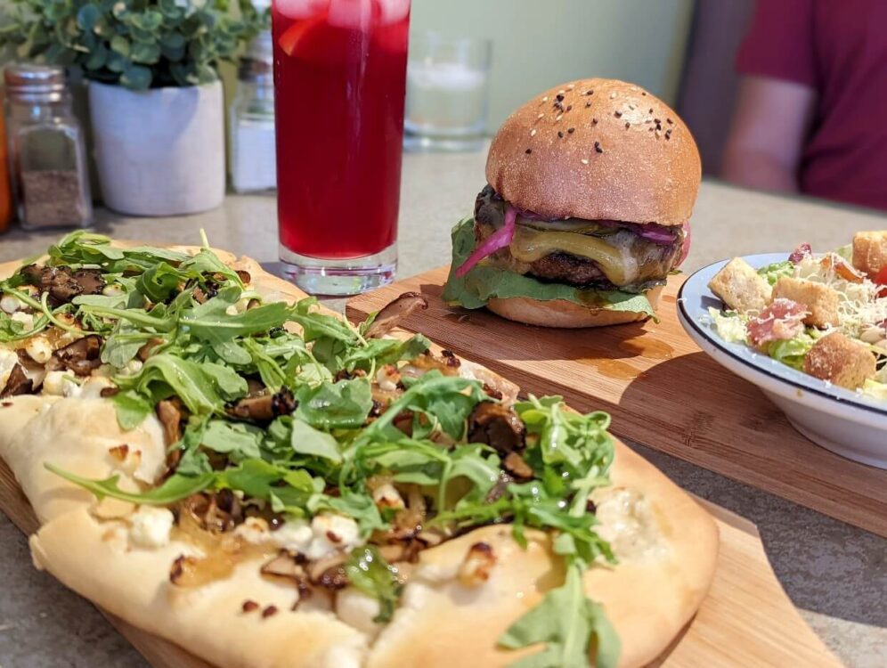 在Naere餐厅的午餐特写，大饼靠近镜头，汉堡和沙拉在背景中